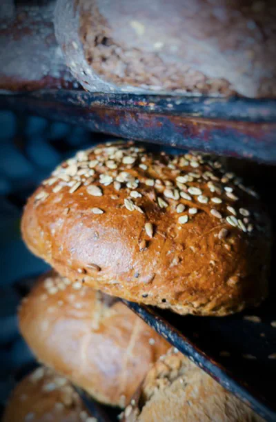 Our master baker proudly displaying fresh artisan bread loaves